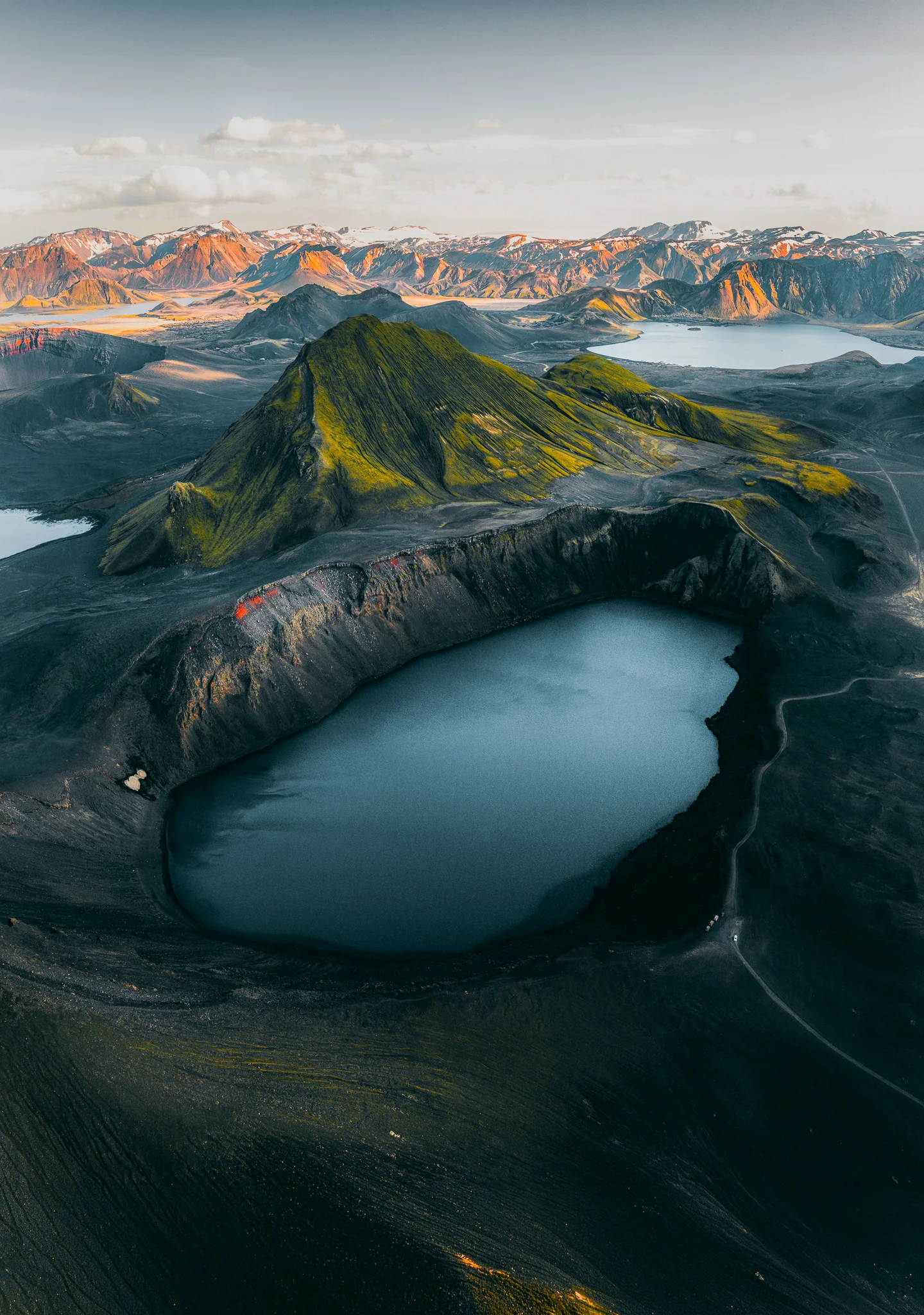 A blue crater lake surrounded by dark volcanic ridges in Iceland