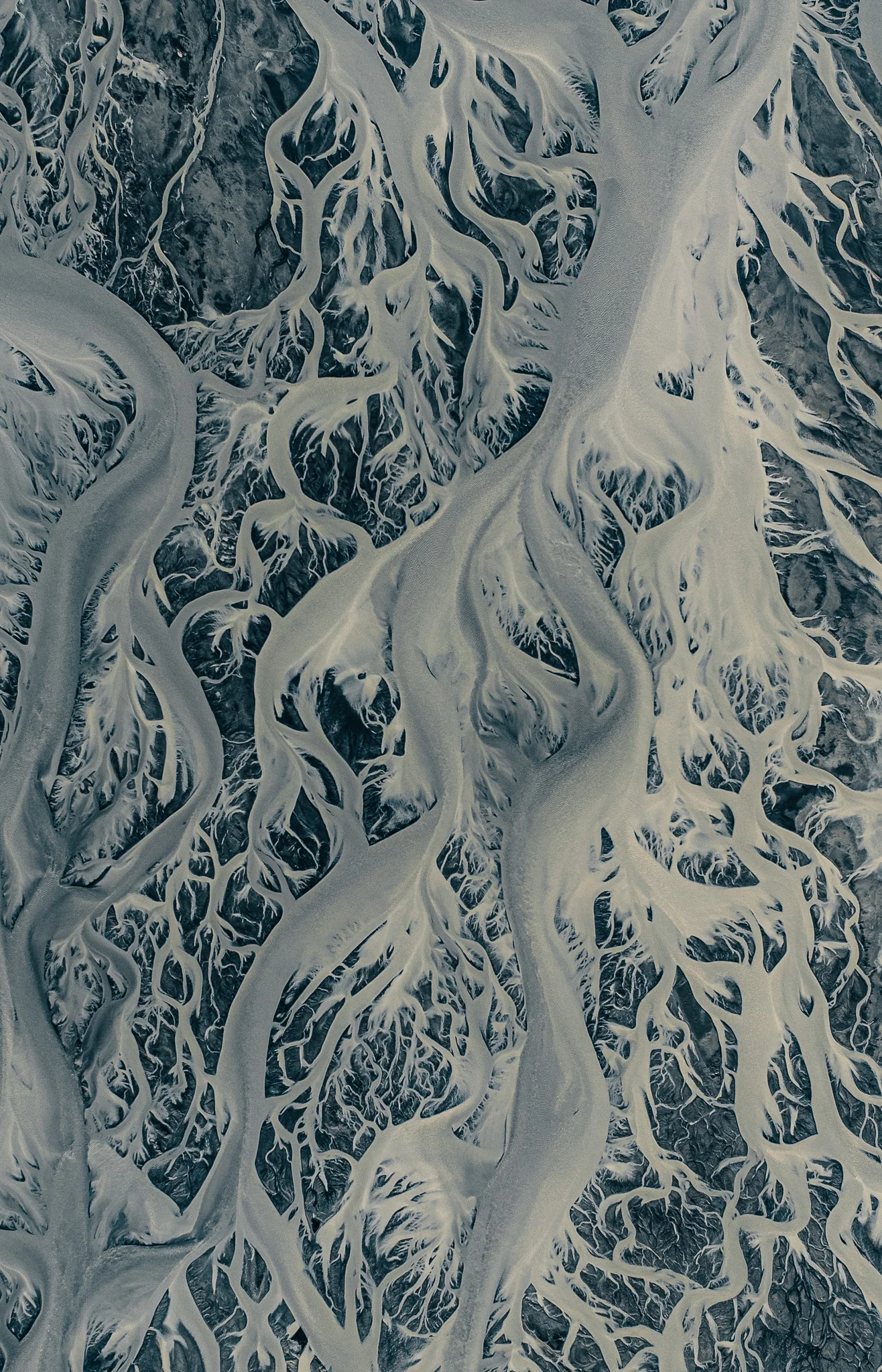 Glacial rivers branching across black volcanic sand in Iceland