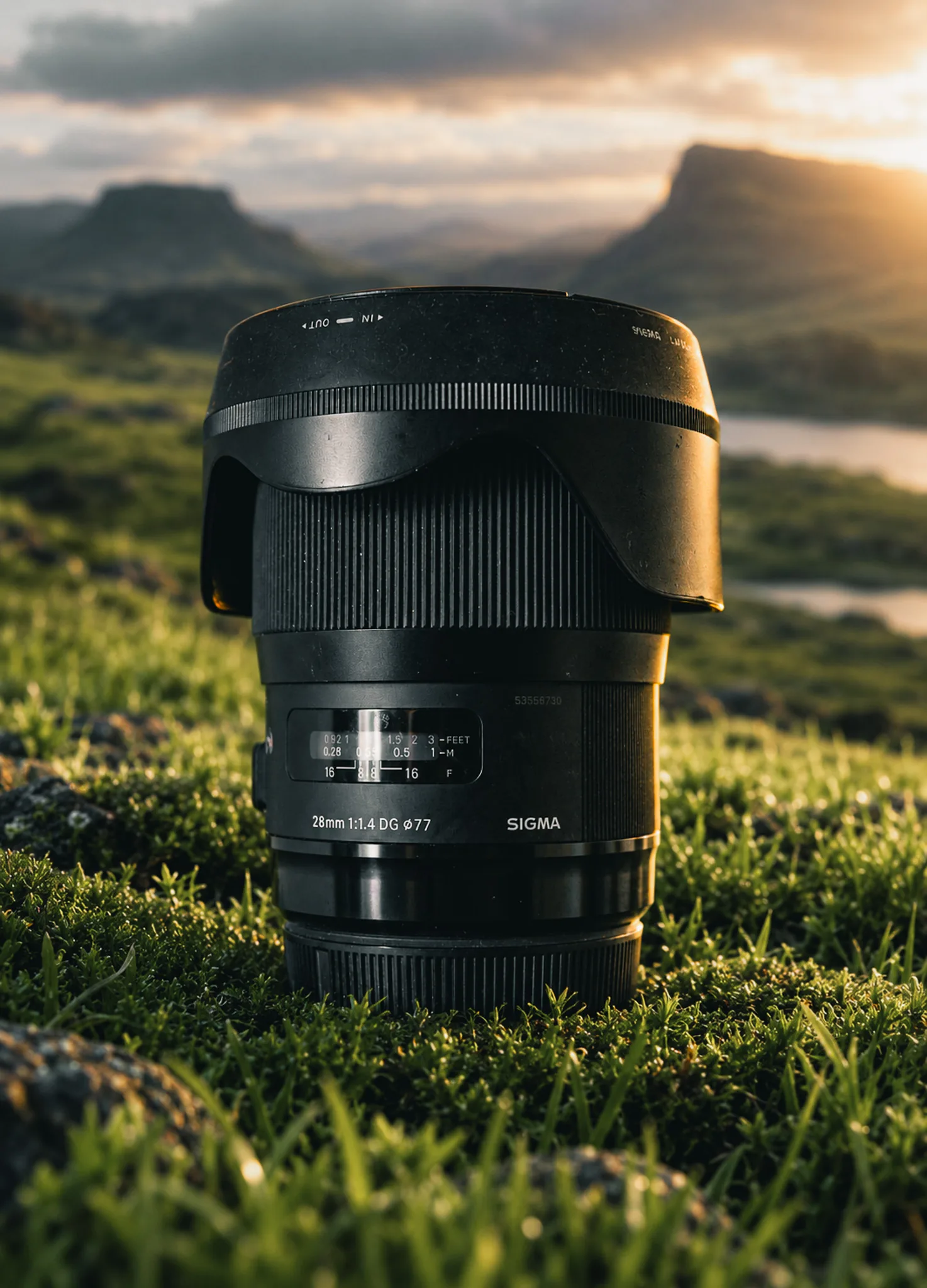 A Sigma camera lens photographed in a sunlit landscape